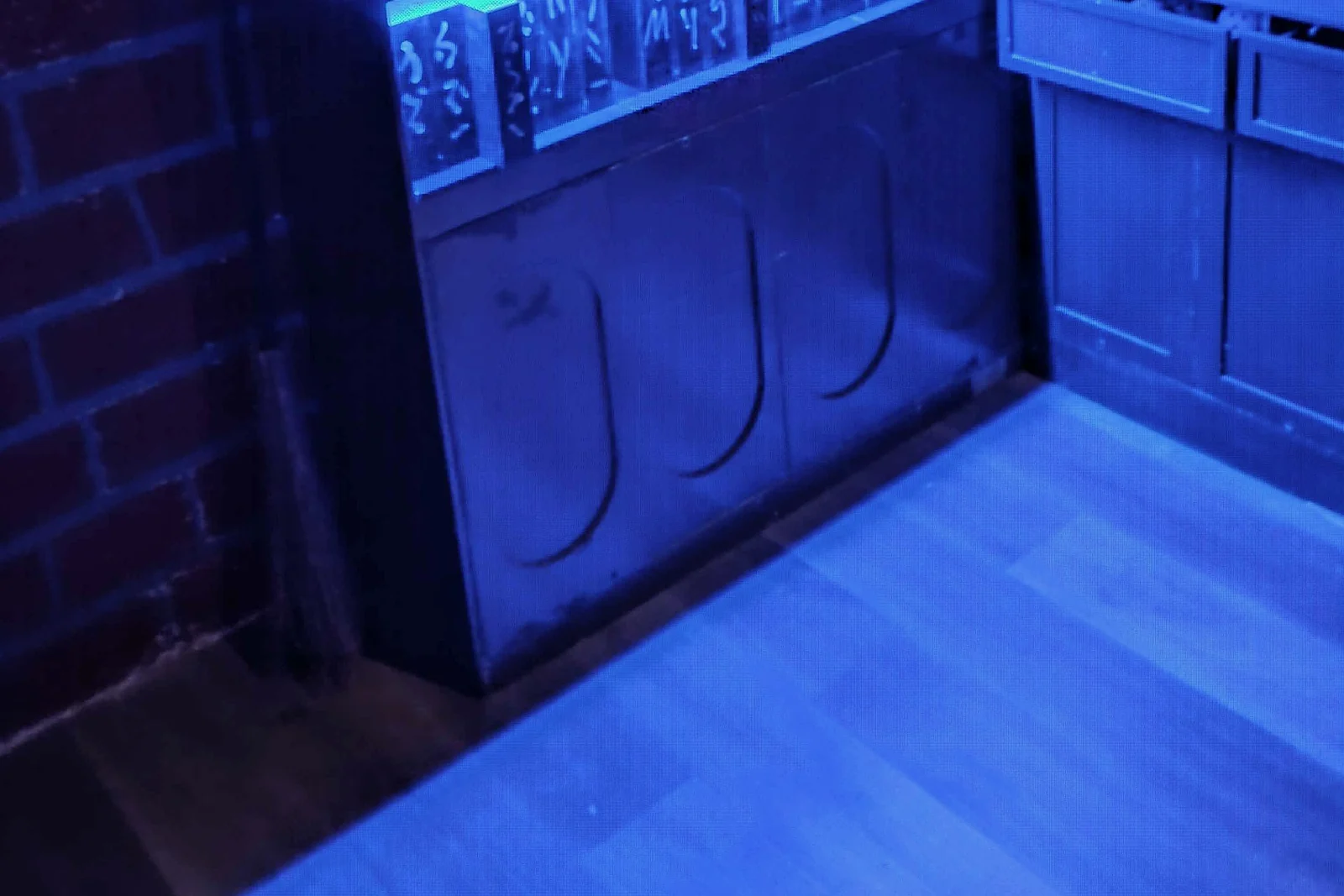 Enchanted classroom shelves revealed under blue game lighting inside Academy of Magic